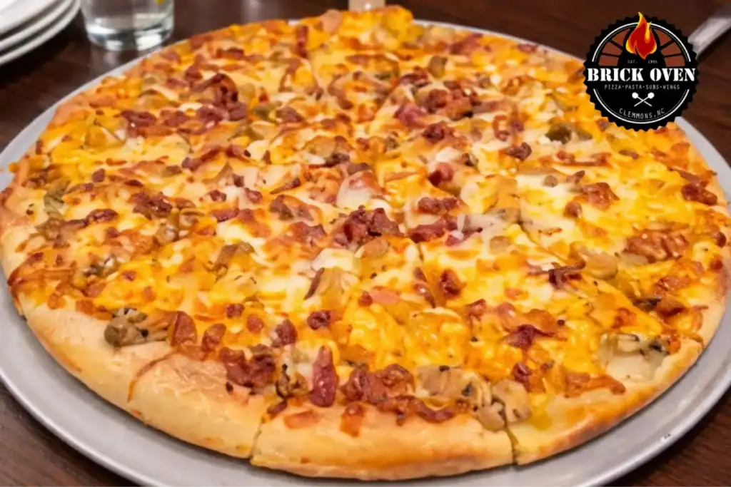 Close-up of a fully cooked pizza topped with bacon, cheese, and vegetables on a metal tray.
