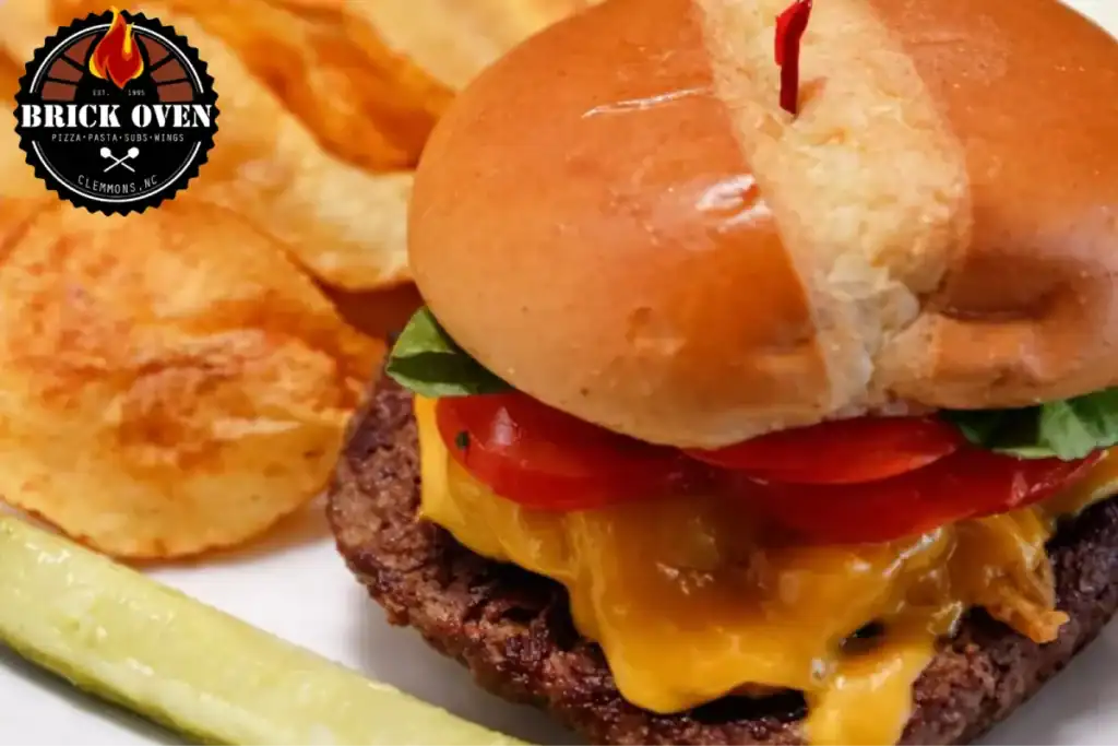 Cheeseburger with melted cheese, chips, and pickles on a plate from a restaurant