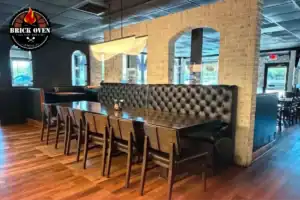Pizzeria dining area with booth seating and tables.
