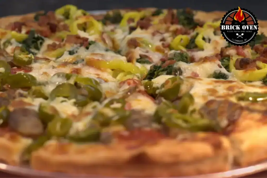 Fresh pizza topped with peppers, cheese, and vegetables.