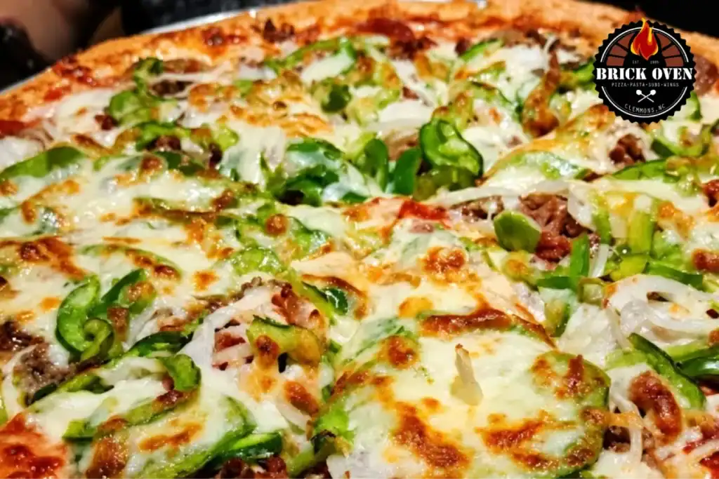 Close-up pizza topped with green peppers, onions, and melted cheese.